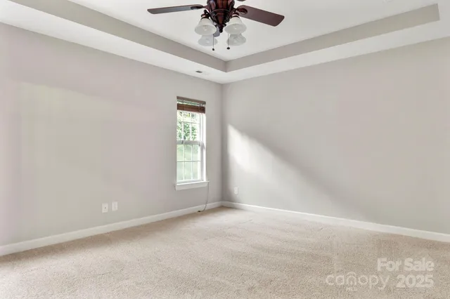 en empty room with windows and ceiling fan