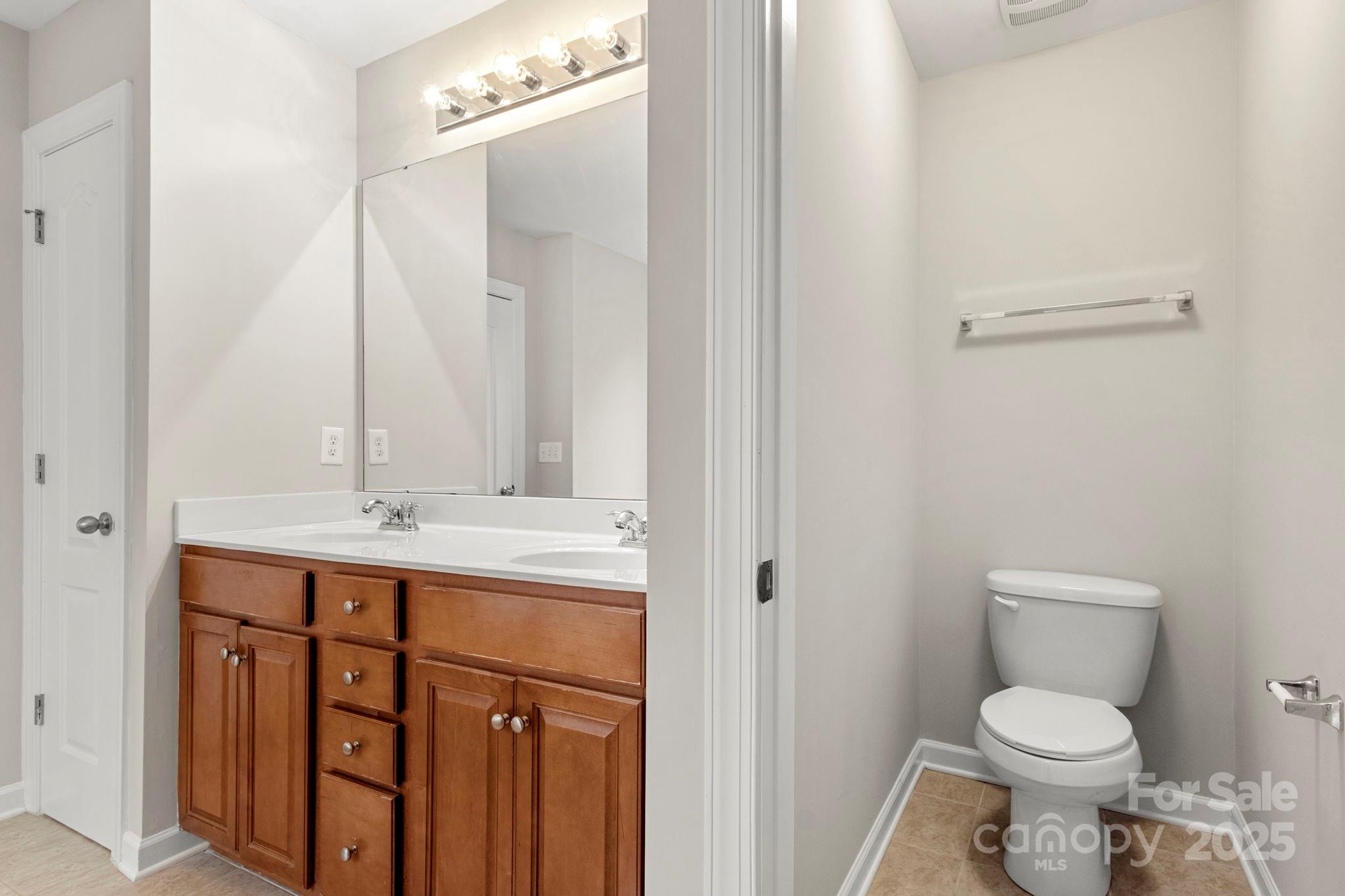 6927 Maricopa Road Charlotte, NC 28277 - Photo 27 of 32 a bathroom with a toilet sink and mirror