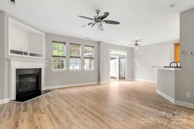 a view of an empty room with a fireplace and a window