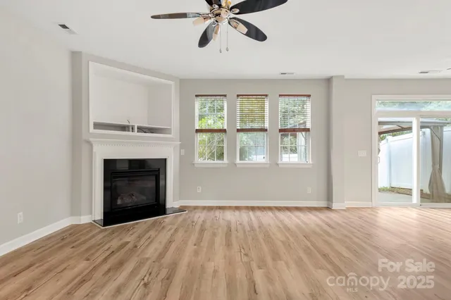 a view of empty room with wooden floor and fireplace