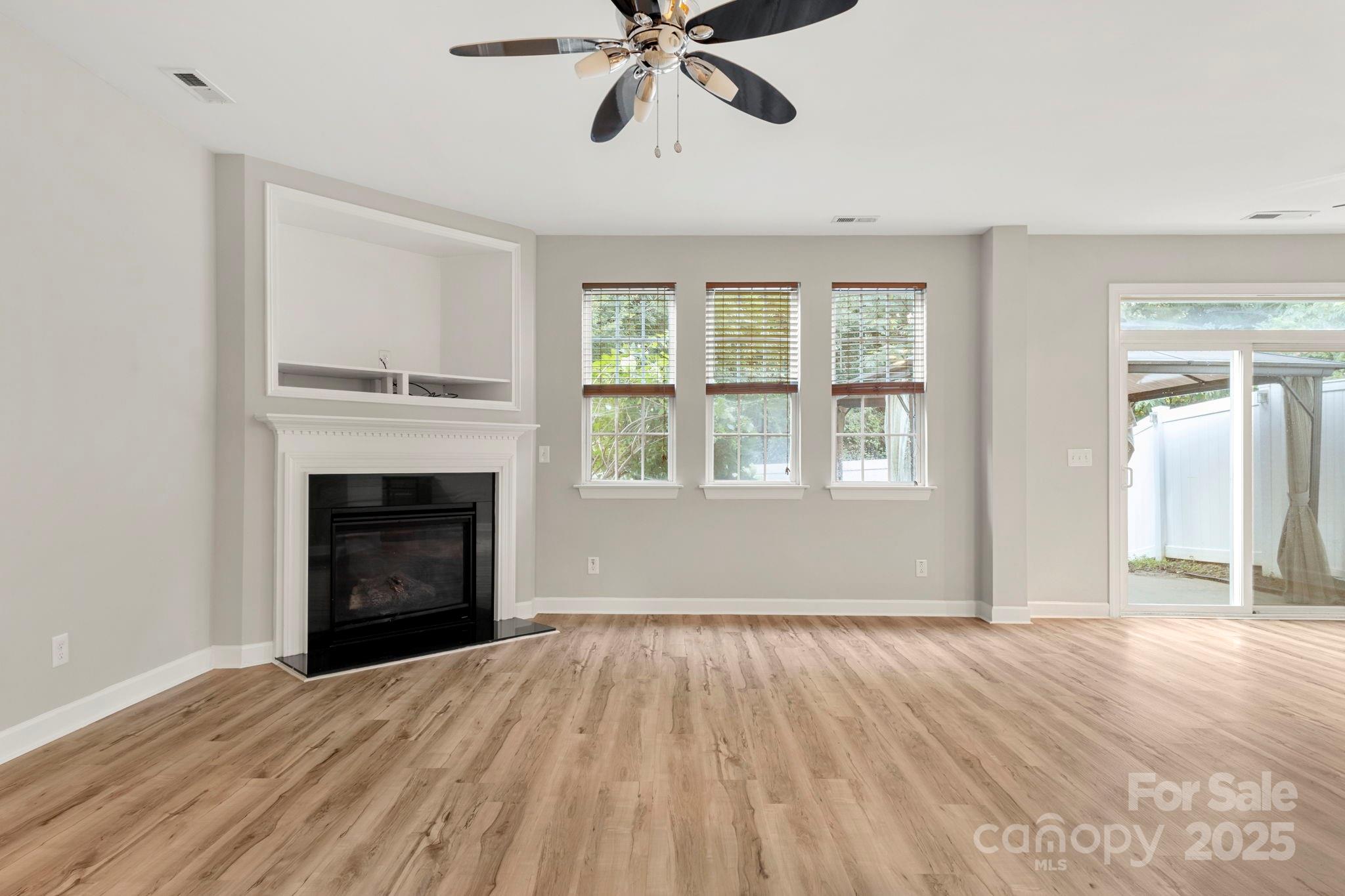 6927 Maricopa Road Charlotte, NC 28277 - Photo 5 of 32 a view of empty room with wooden floor and fireplace