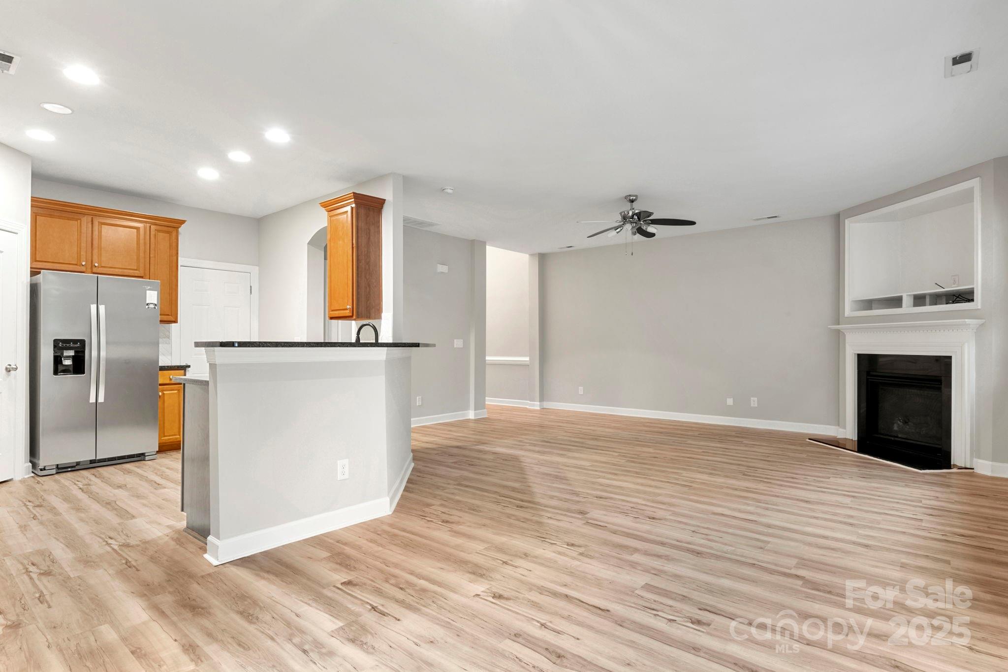 6927 Maricopa Road Charlotte, NC 28277 - Photo 8 of 32 a view of a kitchen with wooden floor and a ceiling fan
