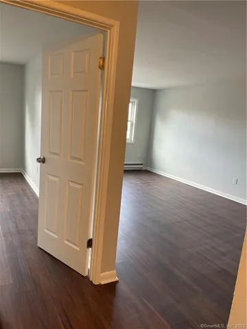an empty room with wooden floor and closet area