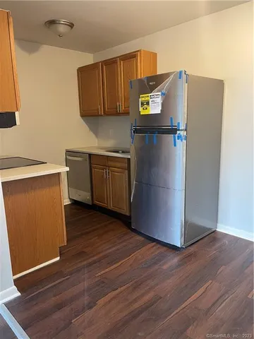 a kitchen with stainless steel appliances a refrigerator sink and wooden floor