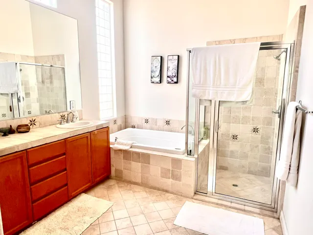 a spacious bathroom with a tub sink and shower