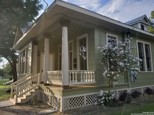 a view of a house with a small yard and wooden floor and fence