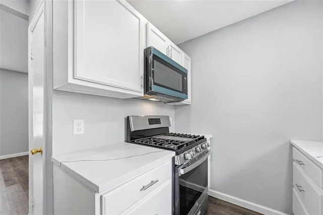 a kitchen with stainless steel appliances granite countertop a stove and a microwave