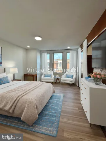 a spacious bedroom with a large bed and wooden floor