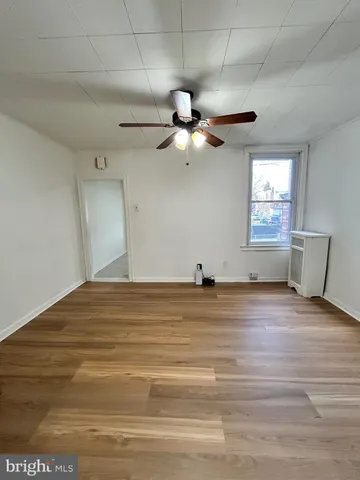 a view of empty room with window and ceiling fan