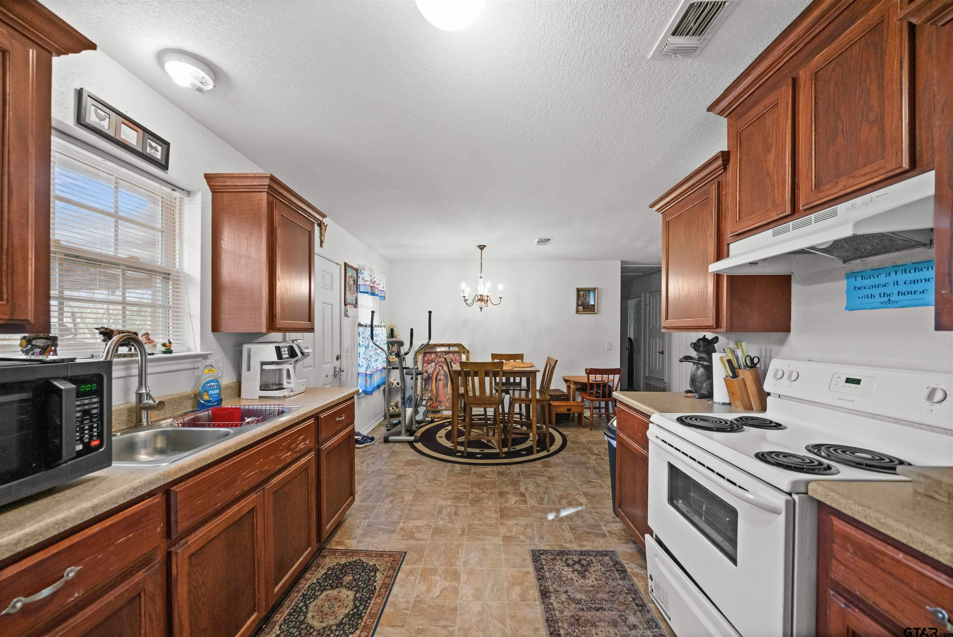 803 Sims Avenue Jacksonville, TX 75766 - Photo 11 of 23 a kitchen with stove a sink and a refrigerator