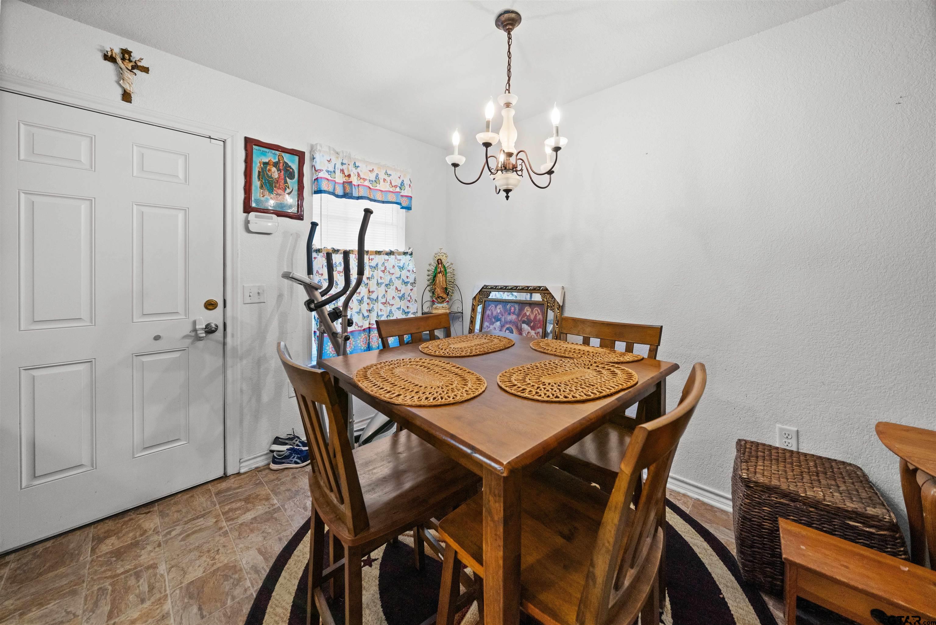 803 Sims Avenue Jacksonville, TX 75766 - Photo 12 of 23 a view of a dining room with furniture and chandelier