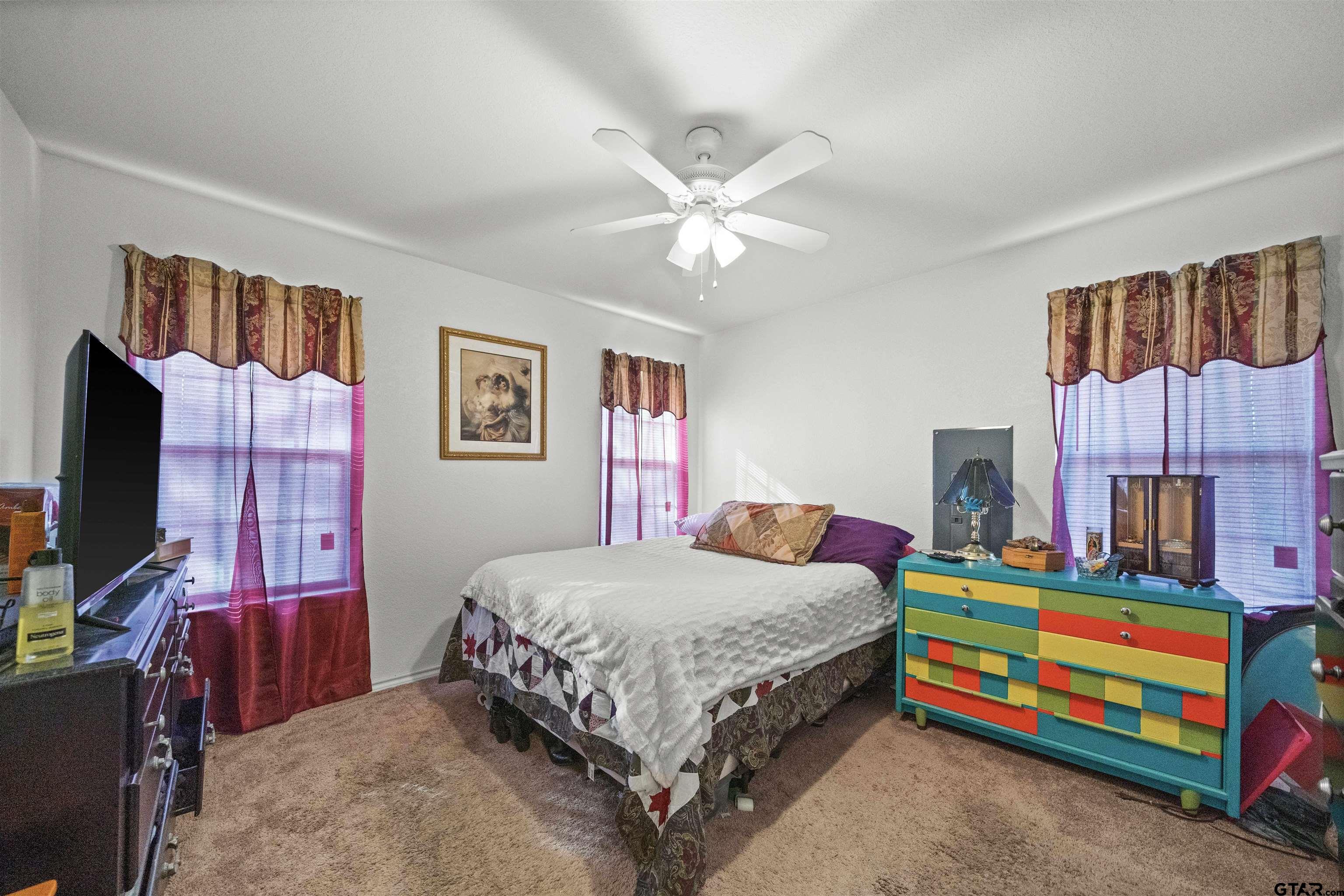 803 Sims Avenue Jacksonville, TX 75766 - Photo 15 of 23 a bedroom with a bed and a flat screen tv