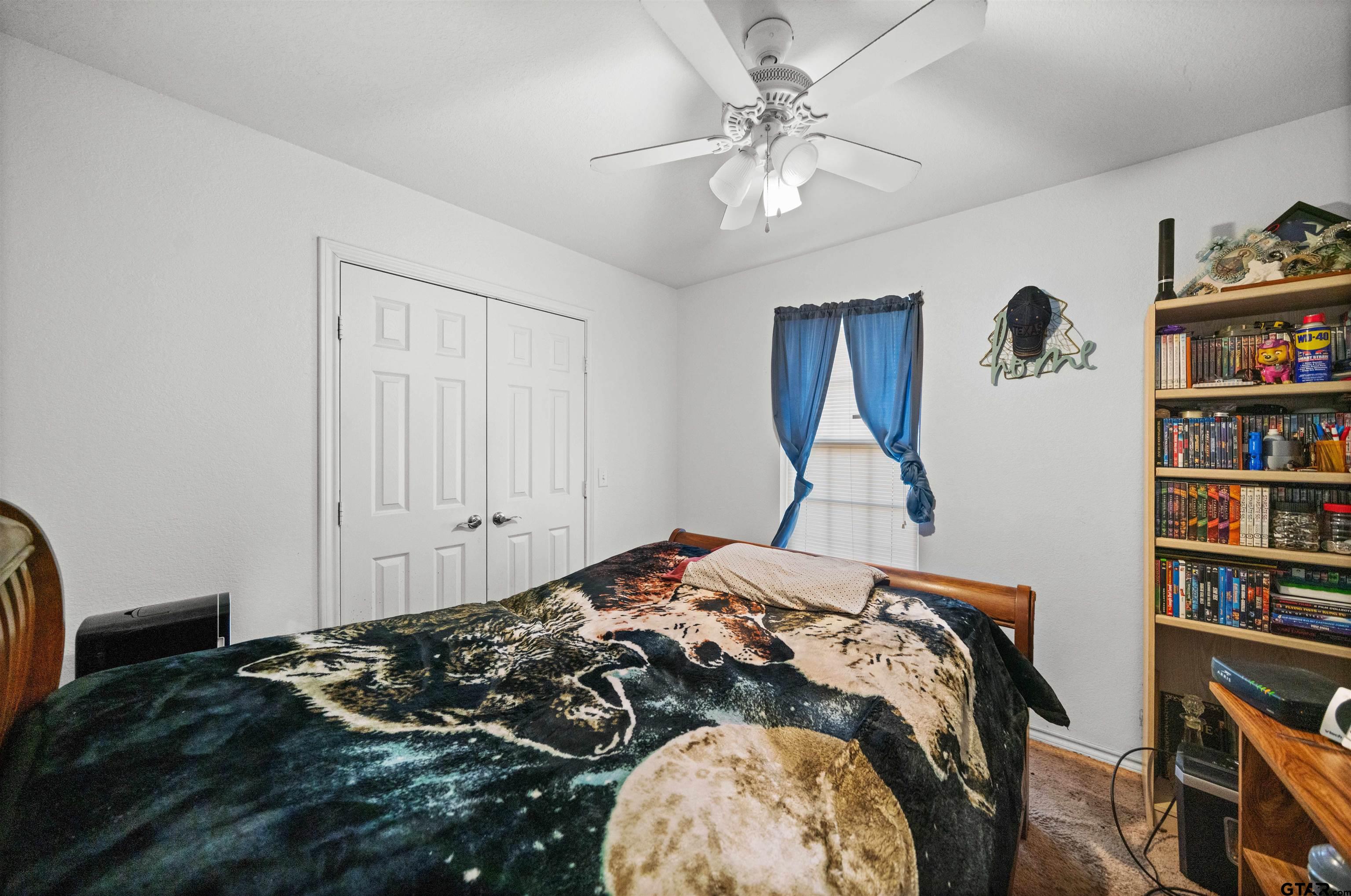 803 Sims Avenue Jacksonville, TX 75766 - Photo 17 of 23 a bedroom with a bed and a chandelier