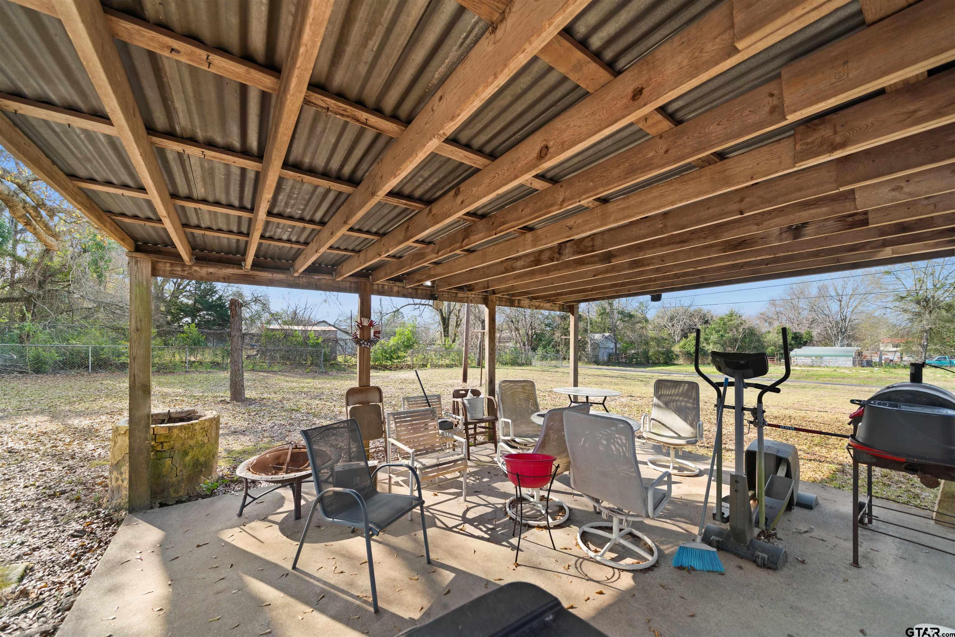 803 Sims Avenue Jacksonville, TX 75766 - Photo 19 of 23 a view of a patio with table and chairs next to a yard