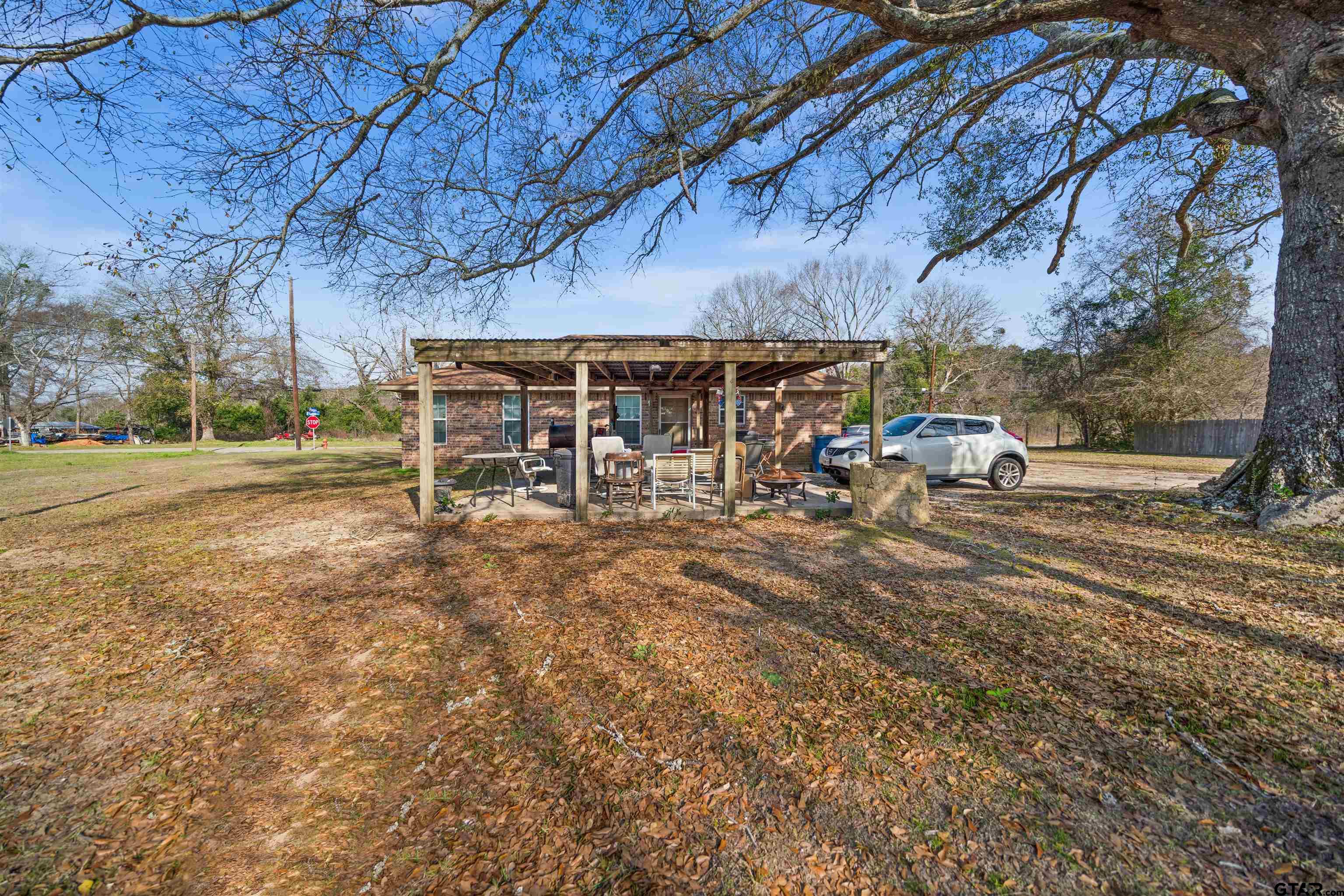 803 Sims Avenue Jacksonville, TX 75766 - Photo 21 of 23 a view of a backyard with table and chairs under an umbrella