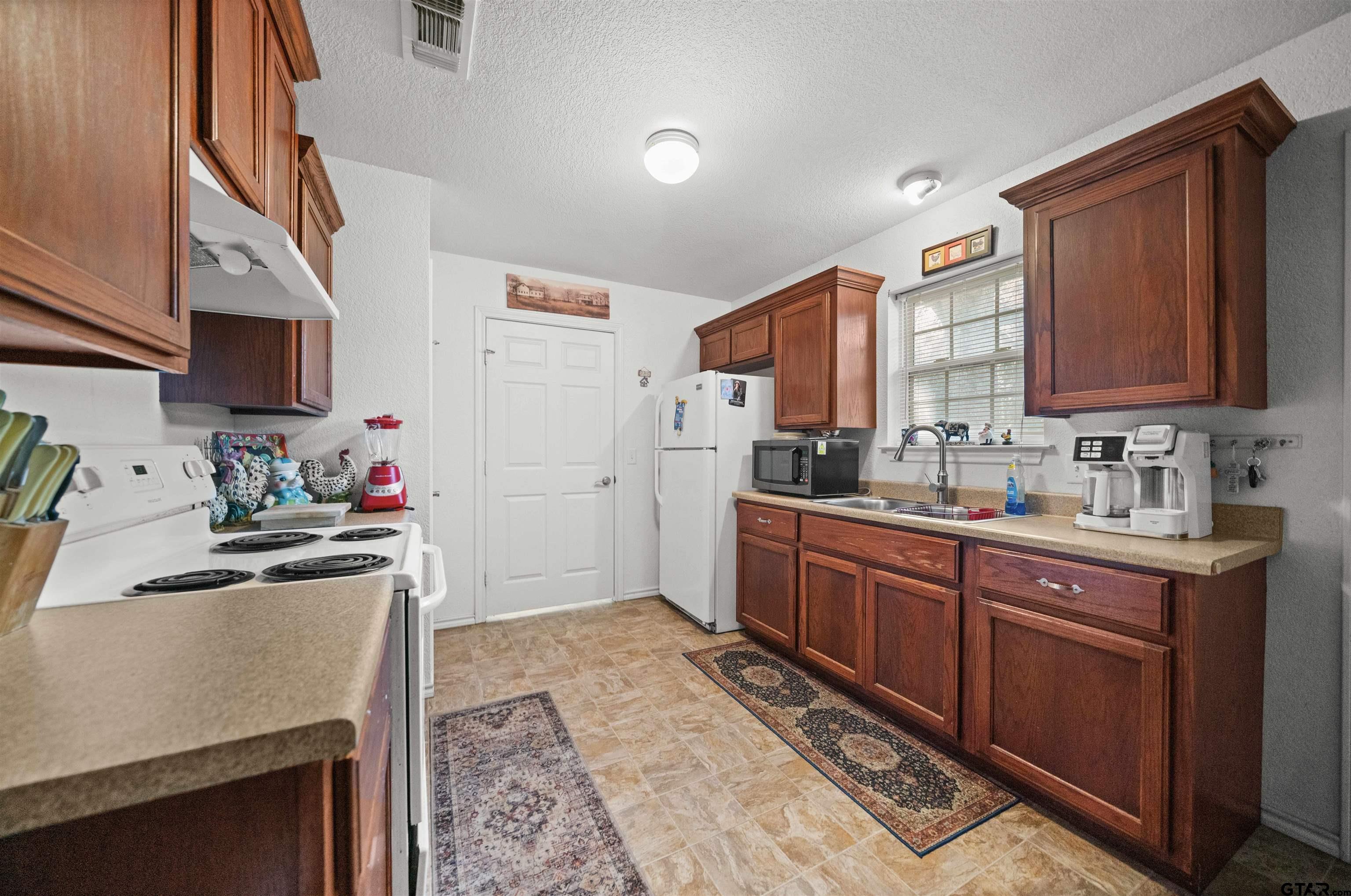 803 Sims Avenue Jacksonville, TX 75766 - Photo 7 of 23 a kitchen with stainless steel appliances granite countertop a sink stove and refrigerator