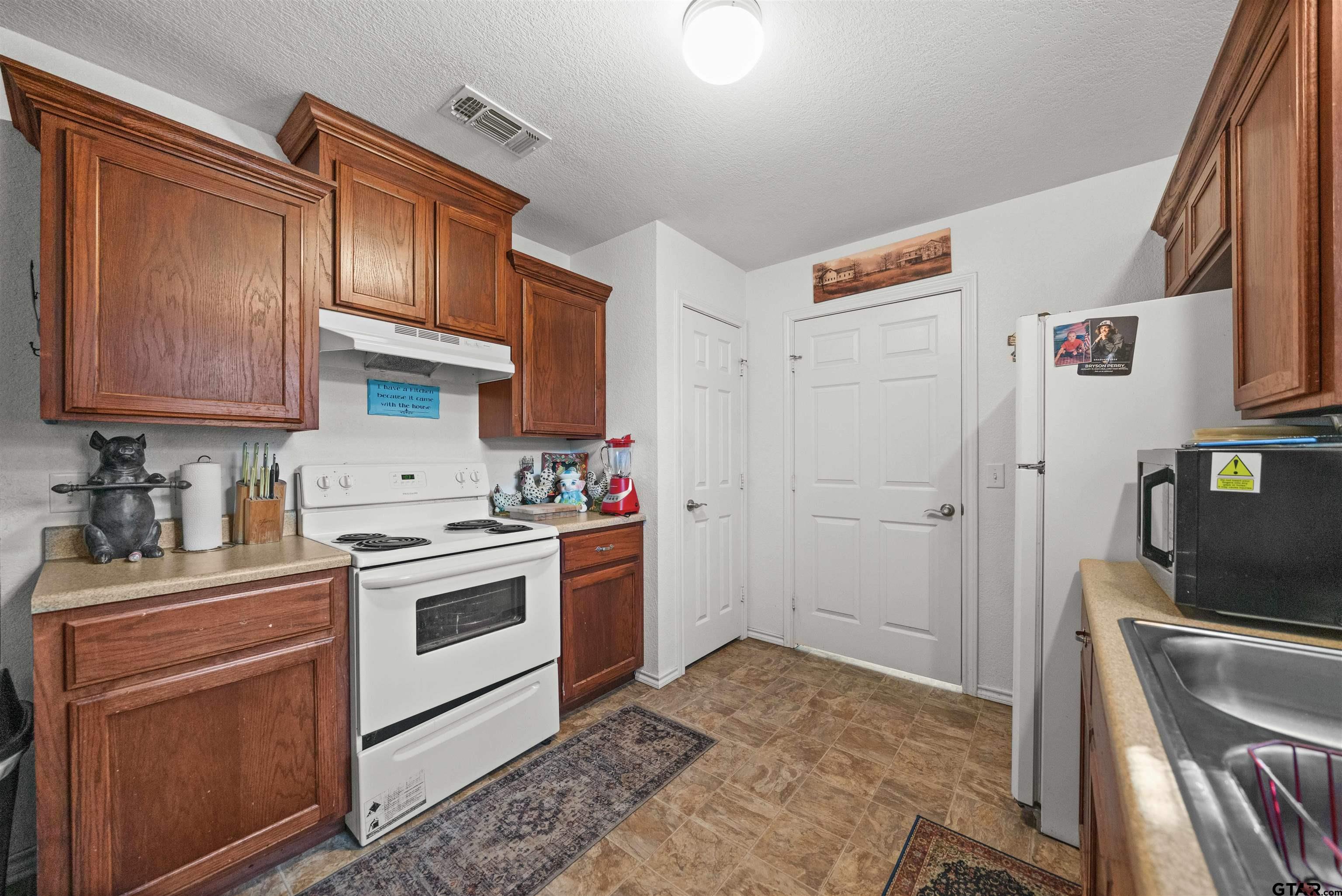 803 Sims Avenue Jacksonville, TX 75766 - Photo 8 of 23 a kitchen with stainless steel appliances granite countertop a sink stove and refrigerator