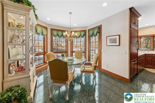 a dining room with furniture a flat screen tv and a floor to ceiling window
