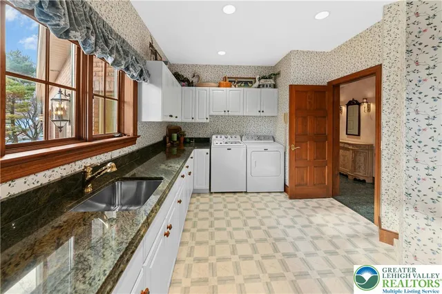 a kitchen with a sink a stove top oven and cabinetry