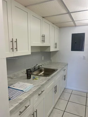 a kitchen with stainless steel appliances granite countertop a sink and a white cabinets