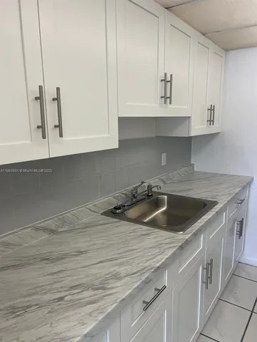 a kitchen with granite countertop a sink and cabinets
