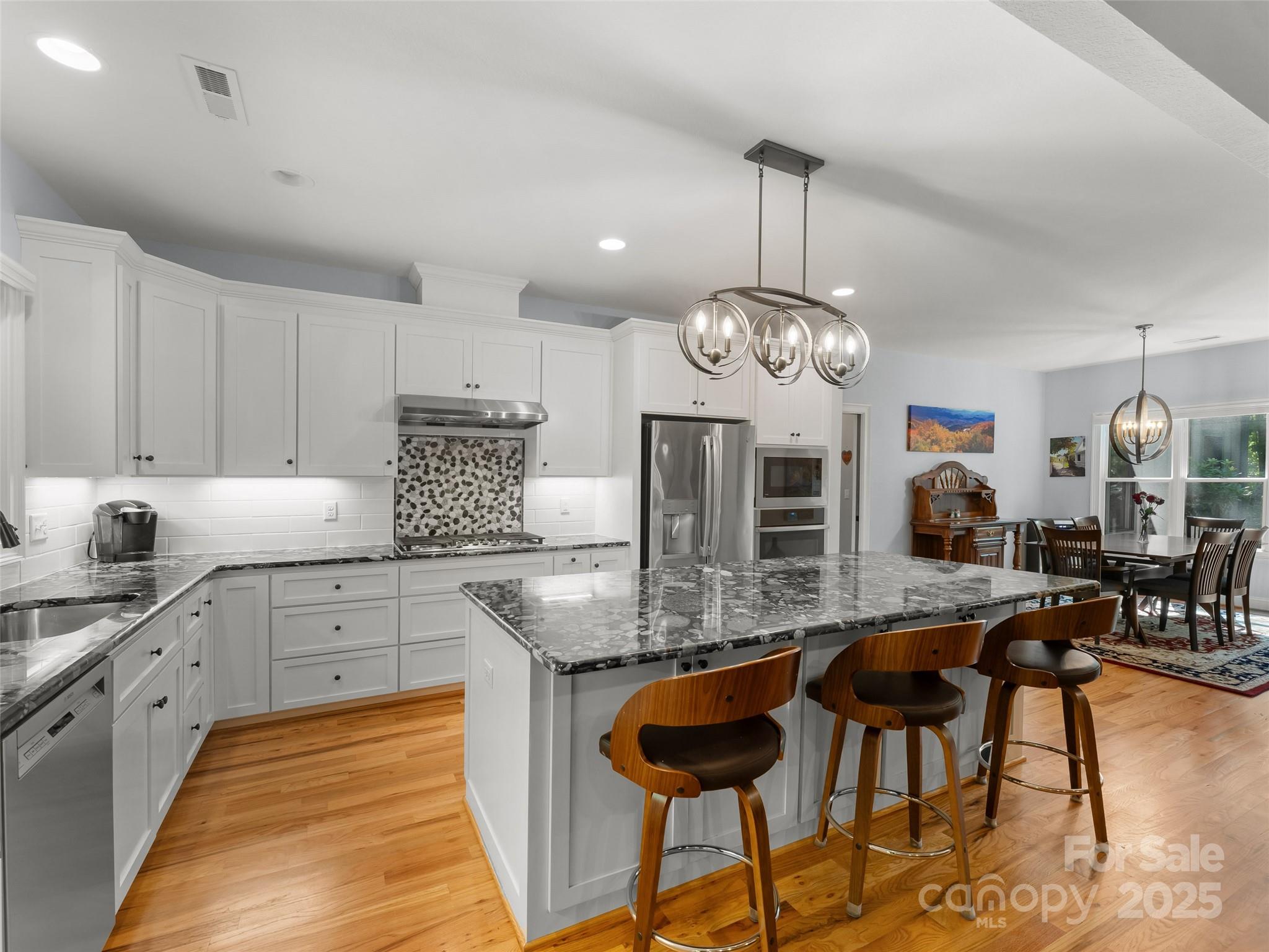 249 Tsisqua Circle Brevard, NC 28712 - Photo 15 of 39 a kitchen with cabinets a counter and chairs