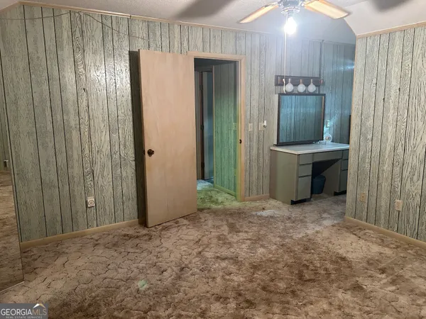 a view of a room with a wooden door and furniture