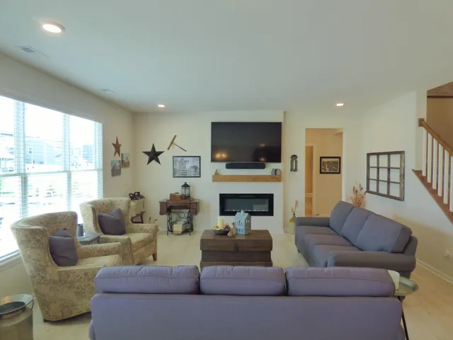 a living room with furniture a flat screen tv and a fireplace