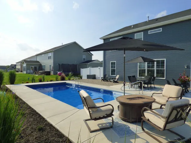 a swimming pool with outdoor seating and yard