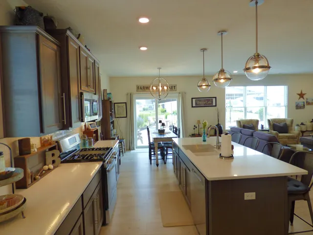 a view of a dining room and livingroom with furniture wooden floor a chandelier