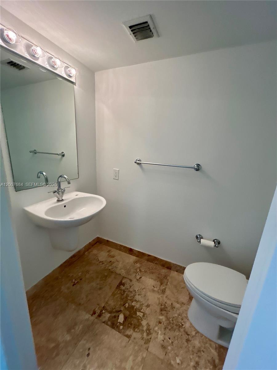 41 Southeast 5th Street, Unit 703 Miami, FL 33131 - Photo 12 of 18 a bathroom with a sink a toilet and shower