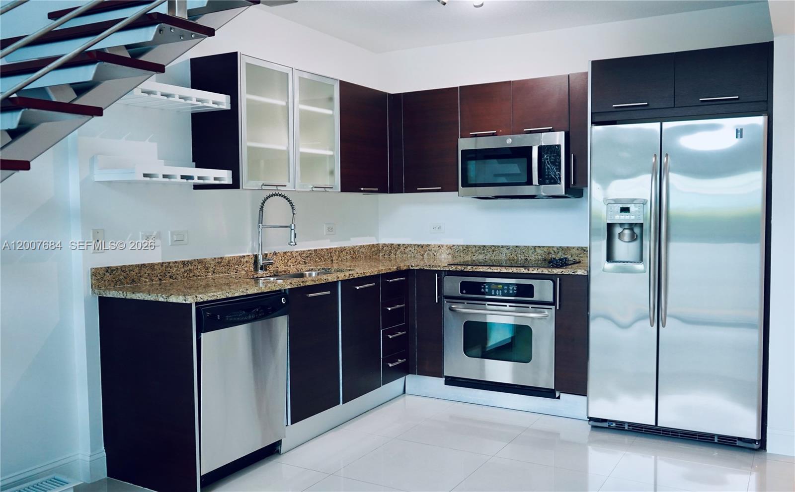 41 Southeast 5th Street, Unit 703 Miami, FL 33131 - Photo 5 of 18 a kitchen with stainless steel appliances granite countertop a stove and a refrigerator