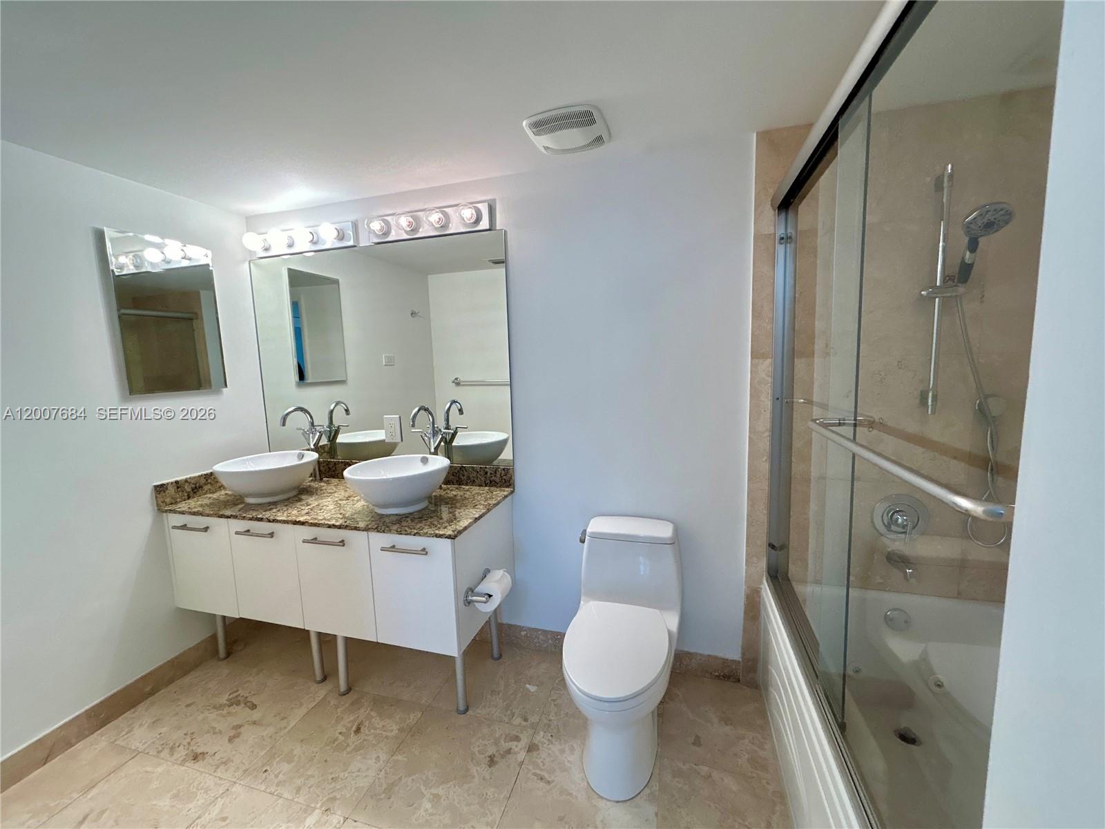 41 Southeast 5th Street, Unit 703 Miami, FL 33131 - Photo 10 of 18 a bathroom with a sink toilet a mirror and shower