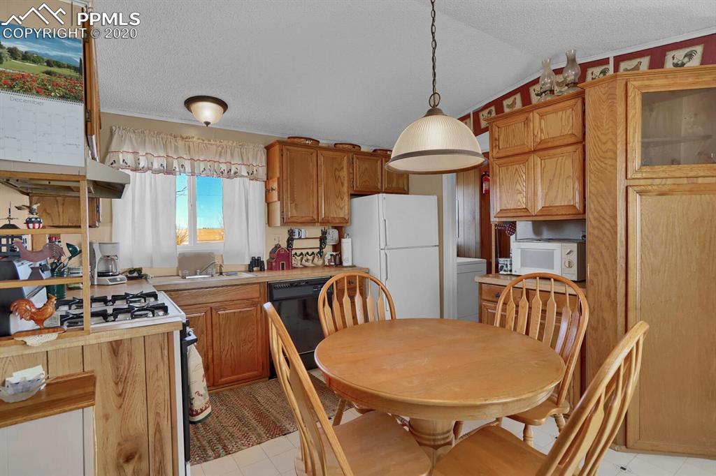 4685 Yoder Road Yoder, CO 80864 - Photo 11 of 32 Kitchen offers a range, dishwasher, refrigerator, disposal, and over the range vent.