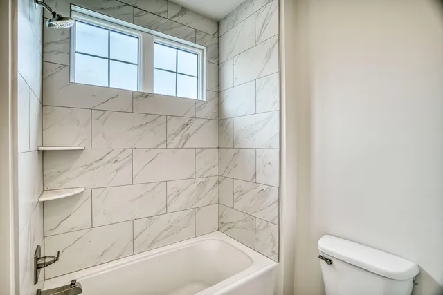 a bathroom with a bathtub and toilet