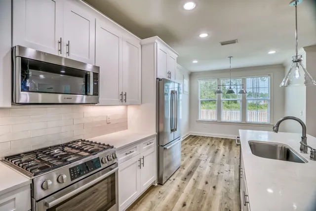 a kitchen with granite countertop a stove a sink and a microwave