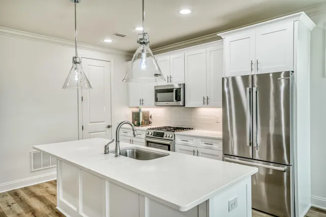 a kitchen with kitchen island a counter top space stainless steel appliances and cabinets