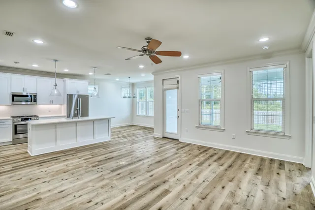a view of an empty room with kitchen appliances and a window
