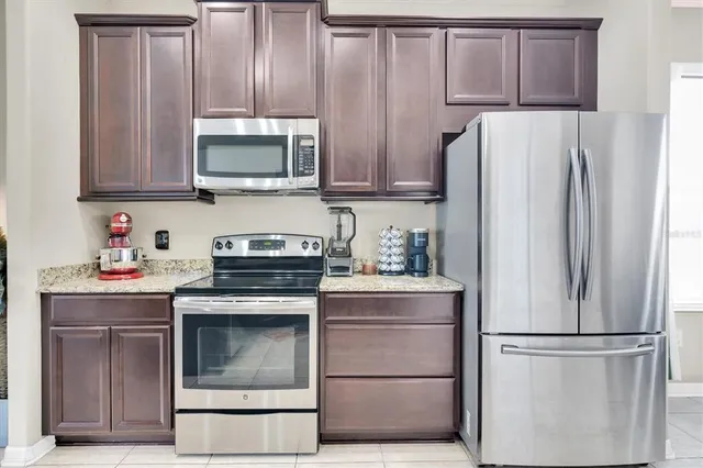 a kitchen with granite countertop white cabinets and stainless steel appliances