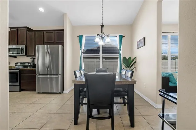 a dining room filled counter top space a refrigerator and furniture