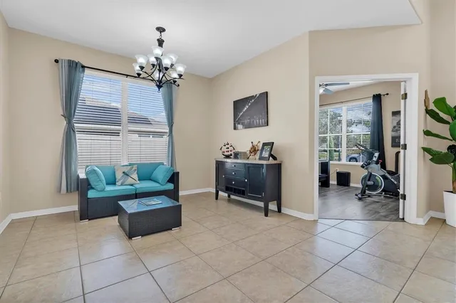a living room with furniture a chandelier and a window