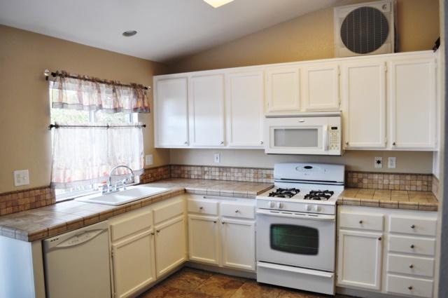 3153 Quarry Road Palmdale, CA 93550 - Photo 5 of 21 a kitchen with granite countertop white cabinets and white appliances