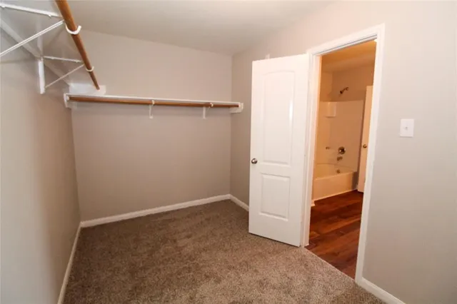 a view of walk in closet with empty racks