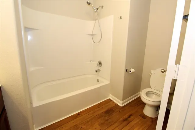 a bathroom with a granite countertop bathtub shower and toilet