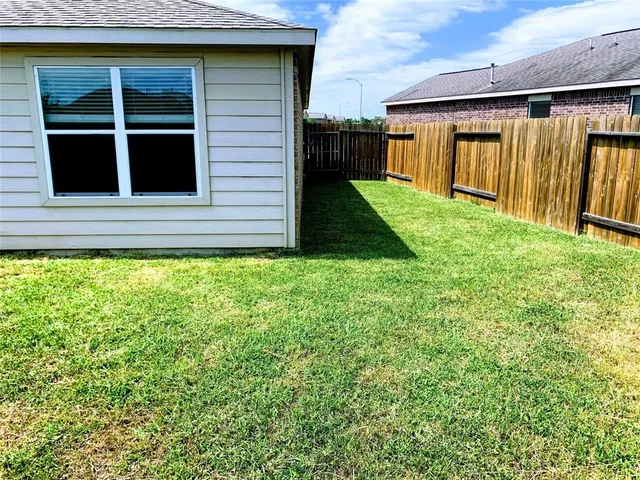 a view of a backyard with potted plants and a large tree