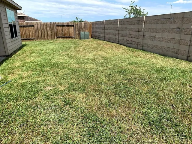 a view of backyard with wooden fence