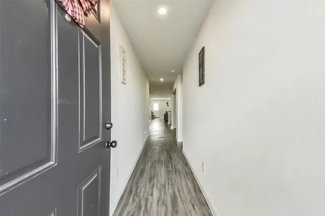 a view of a hallway with wooden floor and staircase