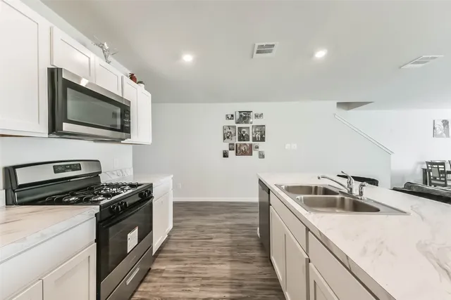 a kitchen with granite countertop a sink and steel appliances
