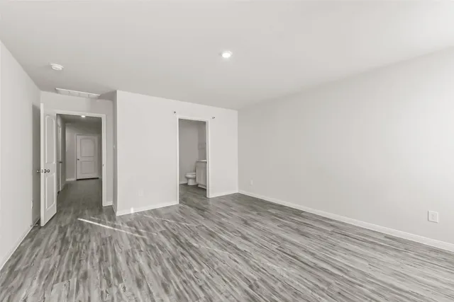a view of an empty room and wooden floor