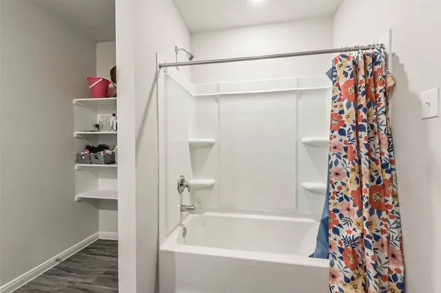a bathroom with a shower curtain and a bathtub